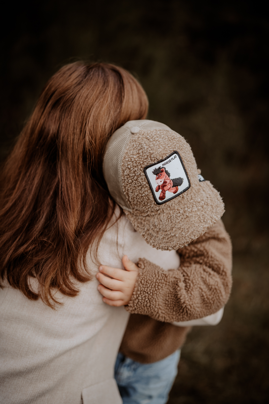 Mutter und Sohn umarmen sich liebevoll. Es sind keine Gesichter zu sehen, da das Foto von oben aufgenommen wurde. Das Foto wird bei der Unterseite zum Ablauf eines Fotoshootings bei dem Punkt zum eigentlichen Shootingerlebnis angezeigt.